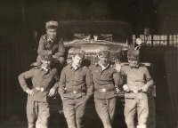 Воротнички расстёгнуты, шапки отформованы, ремни "на яйцах"... Странно, что бляхи не согнуты (у крайнего слева, разве что) или не распрямлены. Сапоги не видно: в "гармошку", небось? 
Петлицы плохо различимы... Автобат, что ли?..
И странно, что только у одного "Классность" и "ВСК". 
И, опять же, только у одного комсомольский значок.
Крайние – похоже, узбеки. Или из тех же краёв.