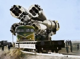 Почему эту фотографию всю не раскарсили? Оставляли бы тогда чернобелой как есть, лучше бы смотрелось

Нижняя часть ракеты должна быть болотно-зеленой (ближе к серому), защитные колпаки на соплах, на крепеже и временные расширительные бачки - все ярко красные.
Установочный агрегат (подемник, на котором ракета едет) - зеленый.