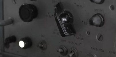 Что он там пытается принять (услышать)? 
Это лабораторный генератор Г4-18А, способен только сгенерировать (передать) слабый сигнал, к примеру для поверки и калибровки радиоприёмных устройств.
Снова на консультантах экономят, выглядит не правдоподобно...
Могли хотя бы поставить ему на стол радиоприёмник "Волна" или "Ишим" 

Всем добра и быть на связи!