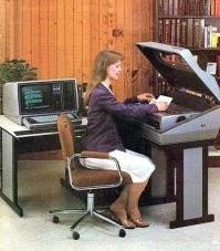 Девка бумагу вставляет в матричный принтер, который помещен в специальный звукоизолирующий бокс 
Ацкая была по шуму вещь