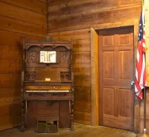 Нет, это не фотошоп, конечно. Оно действительно стоит в Китае в музее фортепиано.  Пишут, что его соорудили сами работники музея в качестве прикола. Играть на нём нельзя.
В то же время угловые пианино существовали. У них была прямая короткая клавиатура и корпус, специально сконструированный, чтобы размещать в углу комнаты.