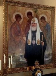 Несколько лет назад лизоблюды подарили предводителю православного духовенства Володьке Гундяеву картину, которую тот горделиво повесил в своей резиденции в Даниловом монастыре и похвастался ею на на сайте патриархии. На картинке патриарха Кирилла пририсовали к репродукции «Троица» Рублёва, на заднем плане, фоном, слегка заметна та самая Троица, со склоненными головами. После появления картины в СМИ отмазывали от кощунственности натюрморта Гундяева с  троицей всем рпц-щным кагалом. Ну, что поделать, юбит гундяйка блестящее,  дорогое и подхалимное... Так вот, засуживать художника никому не пришло в голову, это ж не коврик с изображением женщины с сигарой..коврик потянул аж на почетное наименование "Икона", в отличии от Гундяева с троицей.. что поделать, лицемерие шаманов от РПЦ оно такое... лицемерное..
