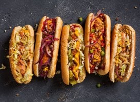 В американский hot dog, кроме сосиски, идут кетчуп и горчица. Как вариант, ещё лук, соленые огурцы, квашеная капуста, жаренный бекон, фасоль.
Как это засунуть во французскую дырку?

И еще. Булки с дыркой никто не печет. Отверстия вырезают в уже готовых булках.