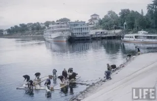 Мне довелось в детстве с мамой ходить довольно далеко на речку и полоскать на мостках белье- даже сейчас вспоминаю это дело с содроганием - белье тяжеленное мокрое, а его тянуть надо в оцинкованных вёдрах на коромысле туда и обратно и стоять согнувшусь, а спину заклинивает, вода проточная ледяная всегда- руки скрючивает... На фото женщины одеты, значит холодно, а мы ходили и зимой тоже...
Это для  совкодрочеров - как было при СССР хорошо! Хорошо, да не очень, а машинки -автоматы были изобретены ещё в 19 веке и в США ещё до ВОВ ими стандартно комплектовались новые дома или прачечные были.