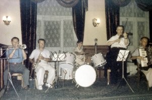 Блё... Какой интересный состав: Саксофон, скрипка, аккордеон, труба, ну и ударные, они везде присутствуют.  А вот что они играют? Что за музыка?  Вот бы послушать...