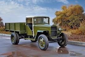 "Полуторка" без дверей, самая, "фронтовая" модификация. Проще некуда. Боковые борта-неоткидные, без запорных механизмов, открывался только задний борт. На фото, машина явно "тыловая"- две фары, роскошь! Крыша-самодельная, из жестяного листа. Видна примятость у правой стойки стекла-явно, прибита гвоздем. У довоенных крыша была прокрашенная, из "шкуры молодого дерматина". У военных модификаций-чисто брезент.  Несколько смущает козырёк над стеклом, явно, оригинальный, как у довоенных машин.