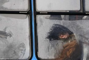 Парень рисует сказочные картины искусственным снегом на окнах