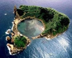 Остров Вилла-Франка на Азорских островах не похожа на пиццу. Просто сняли с такого ракурса и может даже пофотошопили. Уникальность этого острова вовсе не в форме немного напоминающий треугольник, а в идеально круглой кальдере, заполненной водой внутри острова. Такое не часто увидишь.