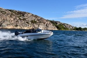 Лодка плывёт по реке взбивая воду позади себя.