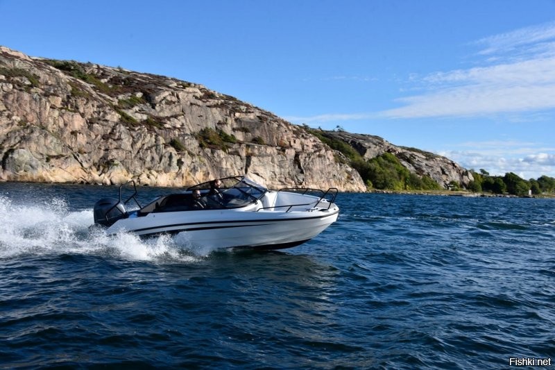 Лодка плывёт по реке взбивая воду позади себя.