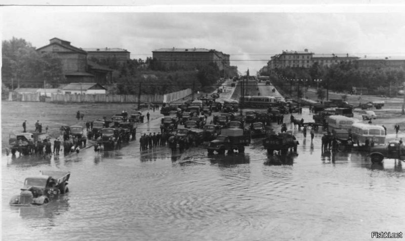 Снимок №5 "Потоп на пл.Труда" из серии снимков 1959 года сделаных жителем Восточного посёлка (это адрес такой) Георгием Викторовичем Жаннин-Перро. Он вообще много снимал Новосибирск и вот часть этой серии. В тот летний день с юго-востока пришла чёрная, налившаяся над Обью, избытком воды, она сначала обрушила водяной шквал на строящийся район "Башня", а потом накрыла Первый соцгород, где все переулки и улицы были мощёны булыжником, а центральную улицу Станиславского упиравшуюся в только, что построенный и открытый новый путепровод под Транссибом, свеже заасфальтированную для пуска троллейбусного движения к заводам.  Ливнёвка на площади Труда в мгновение ока была забита обломками смытого асфальта и площадь превратилась в озеро. Но кому проблемы, а детям и тут игра - вода-то пришла тёплая, нагретая взломанным дорожным покрытием. И вот благодаря Георгию Викторовичу, мы можем увидеть результат работы того ливня.