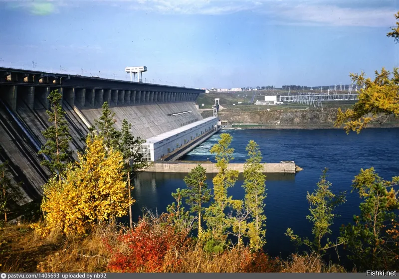 По Братской ГЭС. Сам Братчанин. Ездил по ней тысячи раз. Не совсем понимаю откуда снято. Наверное с правого берега, где сейчас смотровая. Не узнаю эти сопки на снимке - видимо они под водой. Вот фото с правого берега сейчас. Со смотровой и с высоты, чтобы Энергетик видно было за ГЭС.