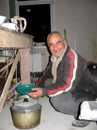 Еду впрок не запасают, поэтому и холодильник пустой. Каждый вечер 3-4 человека, кто с регистрацией, отправляются в универсам за продуктами. В основном брали хлеб, чай, крупу, пряности, говяжью тушёнку и ещё что-то для плова.
А это наш повар, очень хороший, добрый человек. И готовит вкусно, я ел вместе со всеми. Из того набора продуктов он ухитрялся делать подобие плова!