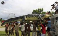 Workers unload 21-foot crocodile robot Longlong from the roof of a van, after it reaches Crocodile Park in Pasay city, metro Manila. ROMEO RANOCO/REUTERS