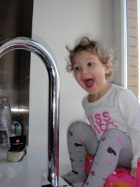 Дочка впервые увидела себя в "кривом зеркале". Отражение на кранене видно на фото (а жаль).