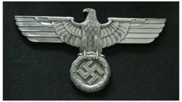 "При этом стоит добавить, что никаких опознавательных знаков на форме летчиков, указывающих на их принадлежность к гитлеровцам, не имелось."
- На заднем плане левее головы главного пилота виднеется "Нэмьэцкий арёль"