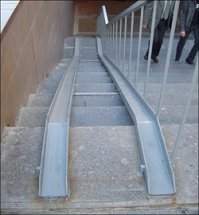 А что не так с этим пандусом ? Таки везде установлены,в любом переходе любого города. Может из-за этого мы и не замечаем какой-то "строительный маразм" потому что привыкли уже к нему и не знаем как может быть по-другому.
Да,он крутой,большой угол наклона,не легко по нему поднимать/спускать коляски,велосипеды и т.д. Инвалиды-колясочники по ним вообще не передвигаются- я не разу не видел. А что ещё ? Перила слева ? Это что-то изменило бы ?