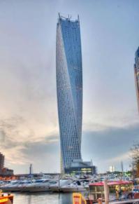 wiki: Строительство башни началось в 2006 году. 7 февраля 2007 года вода из рукотворного залива, на берегу которого велась стройка, прорвалась на стройплощадку, затопив фундамент будущего небоскрёба. Около сотни рабочих были своевременно эвакуированы из котлована глубиной 20 метров, который вода полностью заполнила за четыре минуты. В связи с этим происшествием возведение здания было заморожено на полтора года, возобновившись в июле 2008 года. 10 июня 2013 года состоялась торжественное открытие Башни Кайан, сопровождаемое салютом и лазерным шоу. С этого момента Кайан является самым высоким перекрученным зданием в мире, переместив шведский небоскрёб Turning Torso на второе место. На открытии владелец здания заявил о смене названия с Башня Бесконечность на Башня Кайан, сказав, что хочет этому небоскрёбу оригинальное имя, не встречающееся больше нигде в мире, а башен с названием «Бесконечность» в мире несколько.