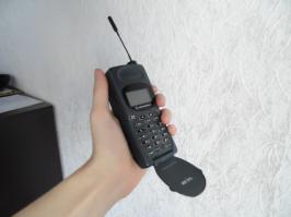 У меня все еще есть первая родительская мобила, купленная в 97-ом - motorola m70( фото не мое). С родным аккумом он имел вполне адекватные размеры( на втором фото), но держал мало, поэтому был куплен аккум увеличенной емкости, а это плюс несколько сантиметров к толщине аппарата.