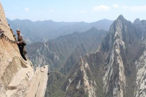 Там и правда страшно, скала почти отвесная...стоит удовольствие 30 юаней, на тебя вешают лямки с двумя карабинами, их поочередно перестегиваешь на трос, смонтированный вдоль всего маршрута(по ходу движения приходится перестегиваться, трос естественно закреплен во многих местах), плюс на всем протяжении деревянная толстая доска под ногами или выемки в камне, но ощущение полета преследует постоянно, из-за движения облаков мимо, и под ногами пропасть метров 800, наверное. Хашань всего 2200 над уровнем моря. И если туда забираться пешком, то тратишь день.

Нужно отметить. что на тропе Лао Дзюня, нам было бы страшнее, но мы ее прошли в тумане, или облаках, и не разберешь, там нет никакой страховки, только цепи по двум сторонам от тропы. 
А кстати, даосские монахи, там бегают без страховки))), и на тропе смерти и на любых тропах  Хуа Шаня вообще, это их горы). С китайского Гора Цветок, она и правда как бы распускается, подобно лотосу, на 5 лепестков-пиков...мы за приезд посетили все 5, это стоит того, все пики разные по содержанию, и по ощущениям.