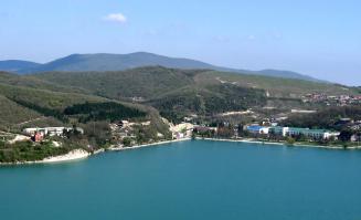 Самое большое озеро на Западном Кавказе под названием "Абрау" располагается на полуострове с гористым рельефом. Озеро имеет воду изумрудного цвета, а дорога, ведущая к нему представляет собой лабиринт из зелени.
Размер озера составляет около 180 гектаров. В летний период его вода нагревается до 28 градусов, поэтому многие люди в нем купаются. Вода в озере Абрау чистая, однако мутный цвет вызван наличием известняка в нем. В озере живут различные виды рыб, например, карпы, окуни, сазаны и другие.
Одной из загадок озера является тот факт, что в него впадает река, на дне бьют несколько ключей, а стока у озера нет, однако, вода куда-то исчезает. Другой особенностью озера Абрау является наличие странной белеющей полоски на глади озера, которую видно по ночам, а в зимнее время эта полоска замерзает последней. Возможно, это можно объяснить особенным действием ветра и воды или ключами, которые бьют на дне озера.