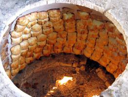 Насколько я знаю у тандыра внутренняя стенка должна быть гладкой. У автора там кирпич и необработанный раствор или глина хз.