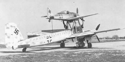 Ju 88 "Mistel"
Германия - 1943
В июле 1943 года фирма Junkers получила задание переоборудовать Ju 88-А в беспилотный самолет-снаряд (в Luftwaffe они имели обозначение "Mistel"), управляемый из одноместного истребителя, укрепленного над фюзеляжем снаряда-носителя. Пилот истребителя вел спарку до точки расцепления, в которой он направлял Ju 88 на цель и отстыковывался.
Истребитель крепился к самолету-снаряду на стальных стойках, укрепленные над центропланом Ju 88 по обе стороны фюзеляжа и сходившиеся под фюзеляжем управляемого самолета вместе с V-образной стойкой от фюзеляжа носителя, образуя два треножника. Верхние точки треножников крепились к главному лонжерону истребителя. Еще одна подпружиненная стойка шла к хвостовой части истребителя. Когда пилот освобождал истребитель, задняя стойка откидывалась назад вдоль фюзеляжа. При касании последнего срабатывал замыкатель, который приводил в действие систему отцепки основных креплений на треножниках. Таким образом предотвращался возможный удар хвостовой части истребителя о заднюю стойку.
Первые 15 Ju 88-А4 были переоборудованы в июле 1943 года. Mistel из Ju 88-А4 с Messerschmitt Bf 109-F, получил обозначение "Beethoven".
Прототип Mistel: Ju 88-А4/Bf 109-F Вначале в Mistel переоборудовали отслужившие свой срок конструкции Ju 88. Из кабины убрали лишнее оборудование, оставив лишь два места экипажа для обучения. Такие машины, получившие обозначение 1, использовали для обучения. Носовой отсек мог быть заменен 3800-кг боеголовкой при помощи быстроразъемных болтов.
Эта боеголовка была успешно испытана на старом французском линкоре-цели "Ошен" во второй половине 1943 г. Проводились опыты и по поражению фортификационных сооружений. При этом тонный стальной стержень кумулятивного ядра пробивал 20 м бетон. Окончательные испытания боеголовки проводились в Peenemünde с апреля по май 1944 г.

Mistel: Ju 88-А4/Bf 109-F Предусматривались два основных приема боевого использования. При первом взлет и полет к цели осуществлялся только при работе двигателей нижнего самолета, а двигатель верхнего самолета запускался только вблизи цели. Второй способ предусматривал использование совместной работы моторов двух машин, а питание бензином верхнего самолета шло из баков нижнего. Когда связка достигала цели, пилот переводил ее в пологое пикирование. На безопасной дистанции истребитель отцеплялся, а беспилотный самолет пикировал на цель.

Первые пять Mistel 1 поступили на вооружение IV/КG 101. Первый боевой вылет был совершен 24 июня 1944 г. Вылет не удался, так как истребителю пришлось отцепиться еще до цели из-за появления ночного истребителя Mosquito.
Вскоре после этого четыре Mistel под прикрытием истребителей Вf 109-G атаковали суда союзников в заливе Сены. Атака была осуществлена при свете осветительных ракет, но результаты не удалось пронаблюдать из-за дыма горящих судов. Разведка на следующий день показала, что все цели были поражены, но ни одно судно не затонуло.
Воодушевленные этим успехом, Luftwaffe заказали заводу в Mockau (Leipzig) еще переоборудовать в Mistel еще 75 ремонтировавшихся там Ju 88-G1. На этот раз это была связка Ju 88-G1 и Fw 190-A6 или Fw 190-F8, так как их моторы также работали на 95-октановом бензине (Mistel 2; учебный вариант S2). К сожалению, комбинация Ju 88-G с полными топливными баками и боеголовкой с Fw 190 была значительно перезагружена, и при взлете случались аварии из-за разрыва пневматиков. После потери нескольких Mistel при взлете, под фюзеляжем была установлена третья сбрасываемая стойка. Этот вариант получил обозначение Mistel 3.

10.10.1944 на базе IV/КG 101 была образована III/КG 66, предназначенная исключительно для использования Mistel, но уже через 10 дней ее переименовали в II/КG 200. К этому времени было решено использовать все имеющиеся Mistel для атаки британского флота в Scapa Flow. Операция была намечена на декабрь 1944 г. Для этой операции на аэродромах в Дании было собрано 60 Mistel вместе с 5./КG 200, самолеты которой должны были освещать цели. Постоянно стоявшая плохая погода задерживала начало операции, а когда она окончательно прояснилась, установилась полная луна. Неповоротливые Mistel 2, развивавшие не более 380 км/ч могли стать легкой добычей британских ночных истребителей.
Следующее нападение планировалось на март 1945 против советских военных заводов. Было заказано 125 Mistel, 100 из которых требовались для этой операции. В марте аэродромы в Восточной Пруссии, которые планировалось использовать для операции "Eisenhammel", были заняты советскими войсками. Позже II/КG 200 предприняла отдельные атаки мостов на восточном и западном фронтах.
Первой их атакой стал налет 9 марта четырех Mistel из состава II/КG 200 на мосты у Görlitz на Neiße. Оба моста были поражены. Mistel из II/КG 200 использовались для налетов на мосты через Рейн. С апреля для этих же целей привлекались подразделения КG 30, также перевооруженные на Mistel. Почти все Mistel были использованы в этих атаках, а их пилотов вскоре перевели в истребительные части.
Темпы переоборудования возросли и теперь в самолеты-снаряды переделывали строящиеся на заводе Junkers в Bernburg Ju 88-G10 и Ju 88-H4 прямо на сборочной линии. Связка Ju 88-G10/Fw 190-A8 обозначили как "Mistel 3C". Самолет отличался вставкой перед крылом 2.75 м фюзеляжной секции. Fw 190, оснащался парой 270 л накрыльевых баков и подфюзеляжным 300 л баком. Второй и третий фюзеляжные баки Mistel предназначались под 95-октановый бензин, который Fw 190-A8 использовал во время полета в связке. Остальные баки заливались 87-октановым бензином. Аналогичный вариант из связки Ju 88-H4/Fw 190-A8 получил обозначение "Mistel 3B".
Одна из модификаций Mistel 3B с экипажем в три человека служила сверхдальним самолетом наведения "Fuehrungmaschine", неся на себе Fw 190-A8 в качестве собственного эскорта. Mistel оснащался локатором сантиметрового диапазона и имел оборонительное вооружение из пулемета МG 131 в задней части кабины. Под центропланом можно было подвесить два 900 л сбрасываемых бака. Один из последних Mistel состоял из Ta 152-H и Ju 88-G7.
Всего было построено около 250 Mistel различных модификаций.