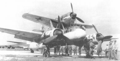 Ju 88 "Mistel"
Германия - 1943
В июле 1943 года фирма Junkers получила задание переоборудовать Ju 88-А в беспилотный самолет-снаряд (в Luftwaffe они имели обозначение "Mistel"), управляемый из одноместного истребителя, укрепленного над фюзеляжем снаряда-носителя. Пилот истребителя вел спарку до точки расцепления, в которой он направлял Ju 88 на цель и отстыковывался.
Истребитель крепился к самолету-снаряду на стальных стойках, укрепленные над центропланом Ju 88 по обе стороны фюзеляжа и сходившиеся под фюзеляжем управляемого самолета вместе с V-образной стойкой от фюзеляжа носителя, образуя два треножника. Верхние точки треножников крепились к главному лонжерону истребителя. Еще одна подпружиненная стойка шла к хвостовой части истребителя. Когда пилот освобождал истребитель, задняя стойка откидывалась назад вдоль фюзеляжа. При касании последнего срабатывал замыкатель, который приводил в действие систему отцепки основных креплений на треножниках. Таким образом предотвращался возможный удар хвостовой части истребителя о заднюю стойку.
Первые 15 Ju 88-А4 были переоборудованы в июле 1943 года. Mistel из Ju 88-А4 с Messerschmitt Bf 109-F, получил обозначение "Beethoven".
Прототип Mistel: Ju 88-А4/Bf 109-F Вначале в Mistel переоборудовали отслужившие свой срок конструкции Ju 88. Из кабины убрали лишнее оборудование, оставив лишь два места экипажа для обучения. Такие машины, получившие обозначение 1, использовали для обучения. Носовой отсек мог быть заменен 3800-кг боеголовкой при помощи быстроразъемных болтов.
Эта боеголовка была успешно испытана на старом французском линкоре-цели "Ошен" во второй половине 1943 г. Проводились опыты и по поражению фортификационных сооружений. При этом тонный стальной стержень кумулятивного ядра пробивал 20 м бетон. Окончательные испытания боеголовки проводились в Peenemünde с апреля по май 1944 г.

Mistel: Ju 88-А4/Bf 109-F Предусматривались два основных приема боевого использования. При первом взлет и полет к цели осуществлялся только при работе двигателей нижнего самолета, а двигатель верхнего самолета запускался только вблизи цели. Второй способ предусматривал использование совместной работы моторов двух машин, а питание бензином верхнего самолета шло из баков нижнего. Когда связка достигала цели, пилот переводил ее в пологое пикирование. На безопасной дистанции истребитель отцеплялся, а беспилотный самолет пикировал на цель.

Первые пять Mistel 1 поступили на вооружение IV/КG 101. Первый боевой вылет был совершен 24 июня 1944 г. Вылет не удался, так как истребителю пришлось отцепиться еще до цели из-за появления ночного истребителя Mosquito.
Вскоре после этого четыре Mistel под прикрытием истребителей Вf 109-G атаковали суда союзников в заливе Сены. Атака была осуществлена при свете осветительных ракет, но результаты не удалось пронаблюдать из-за дыма горящих судов. Разведка на следующий день показала, что все цели были поражены, но ни одно судно не затонуло.
Воодушевленные этим успехом, Luftwaffe заказали заводу в Mockau (Leipzig) еще переоборудовать в Mistel еще 75 ремонтировавшихся там Ju 88-G1. На этот раз это была связка Ju 88-G1 и Fw 190-A6 или Fw 190-F8, так как их моторы также работали на 95-октановом бензине (Mistel 2; учебный вариант S2). К сожалению, комбинация Ju 88-G с полными топливными баками и боеголовкой с Fw 190 была значительно перезагружена, и при взлете случались аварии из-за разрыва пневматиков. После потери нескольких Mistel при взлете, под фюзеляжем была установлена третья сбрасываемая стойка. Этот вариант получил обозначение Mistel 3.

10.10.1944 на базе IV/КG 101 была образована III/КG 66, предназначенная исключительно для использования Mistel, но уже через 10 дней ее переименовали в II/КG 200. К этому времени было решено использовать все имеющиеся Mistel для атаки британского флота в Scapa Flow. Операция была намечена на декабрь 1944 г. Для этой операции на аэродромах в Дании было собрано 60 Mistel вместе с 5./КG 200, самолеты которой должны были освещать цели. Постоянно стоявшая плохая погода задерживала начало операции, а когда она окончательно прояснилась, установилась полная луна. Неповоротливые Mistel 2, развивавшие не более 380 км/ч могли стать легкой добычей британских ночных истребителей.
Следующее нападение планировалось на март 1945 против советских военных заводов. Было заказано 125 Mistel, 100 из которых требовались для этой операции. В марте аэродромы в Восточной Пруссии, которые планировалось использовать для операции "Eisenhammel", были заняты советскими войсками. Позже II/КG 200 предприняла отдельные атаки мостов на восточном и западном фронтах.
Первой их атакой стал налет 9 марта четырех Mistel из состава II/КG 200 на мосты у Görlitz на Neiße. Оба моста были поражены. Mistel из II/КG 200 использовались для налетов на мосты через Рейн. С апреля для этих же целей привлекались подразделения КG 30, также перевооруженные на Mistel. Почти все Mistel были использованы в этих атаках, а их пилотов вскоре перевели в истребительные части.
Темпы переоборудования возросли и теперь в самолеты-снаряды переделывали строящиеся на заводе Junkers в Bernburg Ju 88-G10 и Ju 88-H4 прямо на сборочной линии. Связка Ju 88-G10/Fw 190-A8 обозначили как "Mistel 3C". Самолет отличался вставкой перед крылом 2.75 м фюзеляжной секции. Fw 190, оснащался парой 270 л накрыльевых баков и подфюзеляжным 300 л баком. Второй и третий фюзеляжные баки Mistel предназначались под 95-октановый бензин, который Fw 190-A8 использовал во время полета в связке. Остальные баки заливались 87-октановым бензином. Аналогичный вариант из связки Ju 88-H4/Fw 190-A8 получил обозначение "Mistel 3B".
Одна из модификаций Mistel 3B с экипажем в три человека служила сверхдальним самолетом наведения "Fuehrungmaschine", неся на себе Fw 190-A8 в качестве собственного эскорта. Mistel оснащался локатором сантиметрового диапазона и имел оборонительное вооружение из пулемета МG 131 в задней части кабины. Под центропланом можно было подвесить два 900 л сбрасываемых бака. Один из последних Mistel состоял из Ta 152-H и Ju 88-G7.
Всего было построено около 250 Mistel различных модификаций.