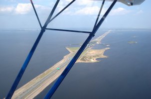 Не совсем над городом: вокруг Кронштадта и над дамбой. Да и при рулении пилот в любой момент мог перехватить управление. Ничего кроме автомобильных прав и удостоверения туриста-краеведа :D Это аттракцион такой, довольно бюджетный.