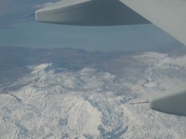 Небоскребы Дубая,облака,поля орошения и заснеженные горы.