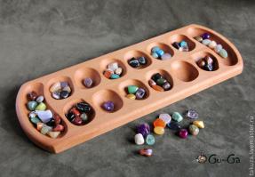 КАЛАХ: Калахи – это дом для камешков одного из игроков, куда складываются победные камни. До начала игры в лунки рассыпаются по одинаковому количеству камней, обычно по 5, 4, 3 или 6 камней в каждую лунку (вместо камней можно использовать семена, фасоль и другие подходящие предметы).

Каждый ход игрок вынимает содержимое одной из лунок и раскладывает его по другим лункам, по одному камню в каждую лунку против часовой стрелки. Калаха противника при раскладывании камешков пропускается. Если последний из камней ложится в свой Калах, игрок делает еще один ход, в противном случае ход передается противнику.

Если последний камень кладется в пустую лунку, а в лунке напротив, лежат камни противника, то все камни из этих двух лунок забираются и кладутся в Калах игрока сделавшего ход. Если же противоположная лунка пуста,(в некоторых разновидностях так же и при не пустой) то игрок забирает последний камень из ячейки и переносит в свой Калах. Игра кончается когда у одного из игроков не остается камней в лунках, тогда другой игрок собирает все оставшиеся камни и переносит их в свой калах. Побеждает тот игрок, у кого камней в Калахе окажется больше.