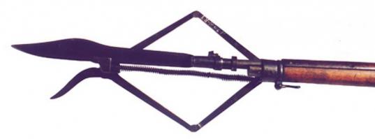 Это тоже штык к винтовке Мосина ( Штык русский экспериментальный 1905 г.)
Длина общая - 38,2 см; длина клинка - 30,6 см; ширина клинка - 2,5 см; ширина клинка в передней трети - 3,7 см; длина трубки - 7,3 см; внутренний диаметр трубки - 1,6 см; ширина обуха клинка - 1,2 см. Клинок стальной плоский, с елманью, однолезвийный, без долов, в передней трети имеет плавное расширение и затем сужается к острию. Обух клинка утолщенный, прямоугольного сечения. В основании клинка обух имеет по бокам две полукруглые выемки. На клинке в месте крепления трубки пробиты два клейма: "П" в круге и "В" со стрелой. Трубка без мулька, с двухколенчатой прорезью слева и хомутиком. Задний конец трубки утолщен. Форма клинка, заточка лезвия, а также наличие двух полкруглых выемок в основании обуха говорят о том, что к этому штыку предусматривалось крепление специальной детали с режущей кромкой, превращающий штык в ножницы для разрезания колючей проволоки. Штык начал использоваться во время русско-японской войны (1904-1905 гг.), хотя боевое применение нашел лишь во время Первой мировой войны. Россия, начало ХХ века (после 1905 года). Задача конструктора понятна - придать оружию режущие и секущие свойства за счёт свойств колющих. То есть, старались повысить универсальность за счёт снижения эффективности. Хорошо, что эта псевдонагината в войсках не прижилась. Таких штыков сохранилось очень мало, и свидетельства об их боевом применении относятся ко временам ПМВ.

Есть предположения (фото 2), что выглядел этот штык в комплекте с инструментом для резки проволочных заграждений. Но боевая ценность сего девайса крайне сомнительна.