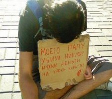 Два парня просят о помощи с одинаковыми табличками
