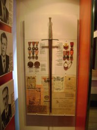 1. «Сталинградский Меч» (двуручный), выкованный в Великобритании и торжественно переданный Черчиллем Сталину на Тегеранской конференции в ноябре 1943-го, как дар британского народа советскому изображен на фото. До этого он в течение 11 месяцев экспонировался во всех крупных городах Англии, Шотландии и Уэльса (знак восхищения британского народа).
Церемониальное "оружие крестоносцев" c золотой "розой Тюдоров" было выковано по указу британского короля Георга VI вручную, из первоклассной шеффилдской стали, и украшено драгоценностями. По клинку кислотой вытравили надпись: ГРАЖДАНАМ СТАЛИНГРАДА • КРЕПКИМ КАК СТАЛЬ • ОТ КОРОЛЯ ГЕОРГА VI • В ЗНАК ГЛУБОКОГО ВОСХИЩЕНИЯ БРИТАНСКОГО НАРОДА.
2.Меч Рокосовского