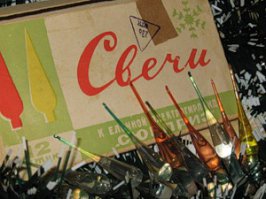 Нашла. Очень здоровская была гирлянда! Свечи.
На металлических прищепках крепились разноцветные патроны в виде свечей. А в них вставлялись прозрачные стеклянные колбочки в виде огоньков. Колбочки были окрашеные, на дне - немного белого твердого вещества, а заполнены прозрачной жидкостью. 
Через несколько минут после того, как гирлянду зажигали, в этих колбочках начинали бегать пузырьки (видимо, под действием тепла)