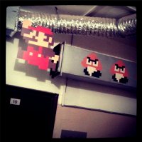 Неплохой стеллаж) А мы вот так замутили в старом офисе дверь входную))

Потом решили развить 8-ми битную тему, и продолжили с Марио над входной дверью))