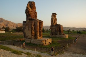 Колоссы Мемнона. 
Две статуи изображают сидящего Аменхотепа III (ок. XIV столетия до н. э.).
Статуи сделаны из блоков кварцитного песчаника, которые были добыты из каменоломни в Джебель-эль-Ахмаре (неподалёку от современного Каира) и транспортированы на 670 км по земле без использования Нила (они были слишком тяжелы для переправки вверх по реке). С учётом каменных платформ, на которых стоят статуи, они достигают 18 метров в высоту. Вес каждой статуи оценивается в 700 тонн.