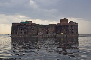 Недалеко от Кронштадта из воды поднимаются молчаливые стены форта «Император Александр I» или «Чумной». История заброшенного сооружения, в котором сто лет назад находилась таинственная лаборатория, до сих пор будоражит воображение петербуржцев.
Военная история форта «Император Александр I» оказалась довольно короткой. В 1838 году Николаем I было принято решение о постройке отдельного крепостного сооружения. Во время Крымской войны и после неё форт много раз модернизировали, и эти меры обеспечили полную неприступность Кронштадта для англо-французского флота. В 1894 году в Гонконге и Кантоне вспыхнула эпидемия чумы. Погибло около ста тысяч человек. Из Китая болезнь стала проникать в другие страны. К 1896 году чума добралась до прикаспийскиих степей. Изолированное от внешнего мира укрепление идеально подходило для смертельно опасных работ, и здесь расположился Комочум — первая в России противочумная лаборатория, где при опытах с опасными микробами погибло несколько врачей. Жители Кронштадта боялись даже ветров, дующих со стороны форта...

Допуск в форт был строго ограничен, сообщение с внешним миром поддерживалось с помощью маленького пароходика под смешным названием «Микроб», который бегал по волнам Финского залива. С Кронштадтом форт связывала телефонная линия, а с Петербургом – телеграф.

Двухэтажный снаружи форт имел внутри три этажа. Здание было симметрично разделено на две половины, у каждой была своя лестница. Одна из камня, другая чугунная. Правая часть, состоящая из служебных помещений была заразная, левая – незаразная.

В форте располагались лаборатории, операционная, конюшни и помещения для других животных, на которых пробовали действия изобретаемых лекарств: коров, коз, верблюдов, обезьян, кроликов и даже северных оленей. Здесь также находились кремационные печи для утилизации отходов и трупов, стерилизатор, прачечная, баня, кухня, электрическая станция, комнаты для врачей, столовая, музей, библиотека — всего и не перечислишь.

Трудно даже хотя бы частично представить себе значение работы всех тех, кто трудился на «Чумном форту», кто дал возможность поставить надёжный заслон самым страшным эпидемиям и спасти тем самым миллионы человеческих жизней.